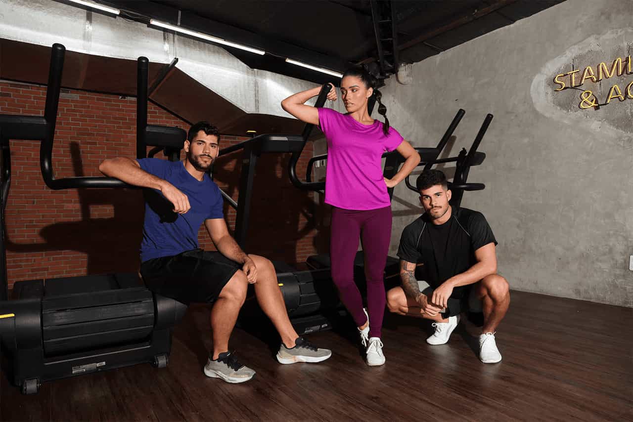 2 homens e uma mulher vestindo roupas de academia
