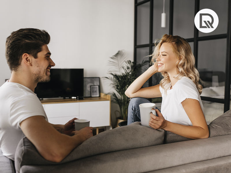 homem e mulher sentados no sofa olhando um para o outro