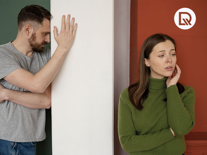 Homem de camiseta cinza com a cabeça na parede e mulher com camisa verde e mao no queixo