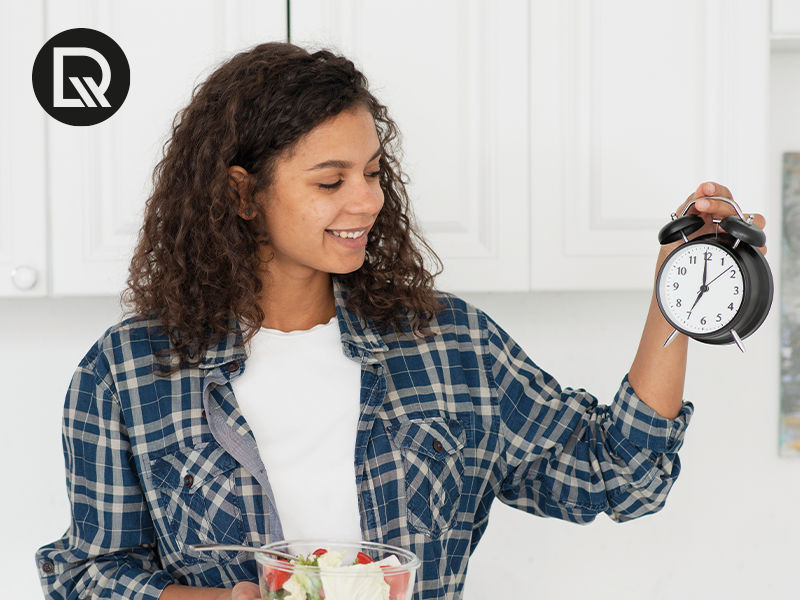 Mulher segurando 1 relogio e olhando com sorriso no rosto