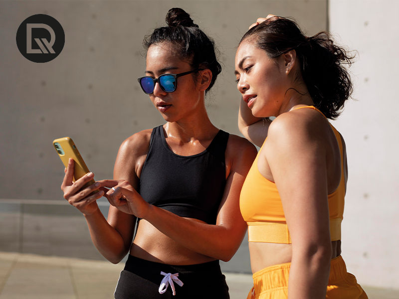 Duas amigas olhando o celular apos praticar exercicio