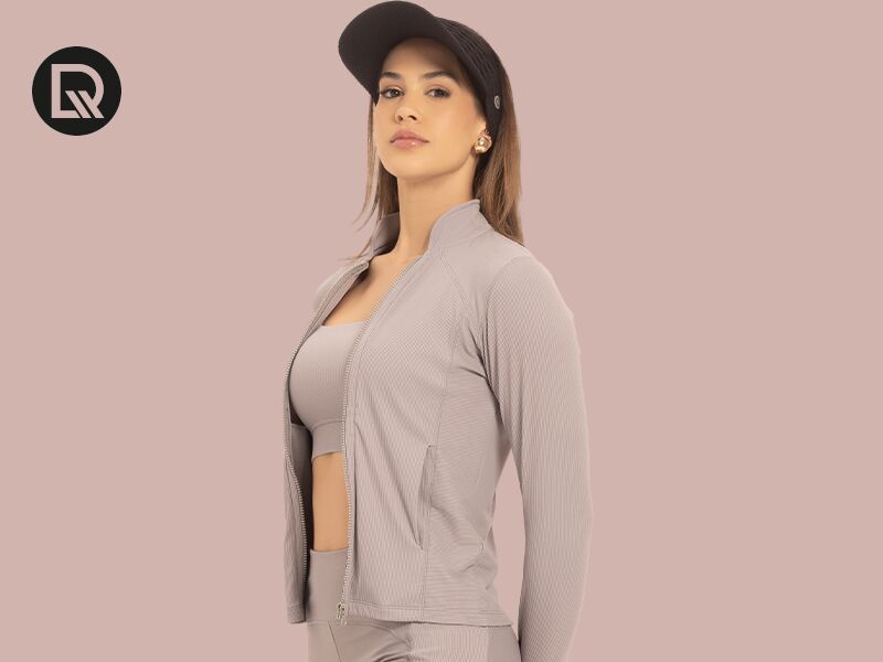 Modelo feminina usando jaqueta e boné esportivos