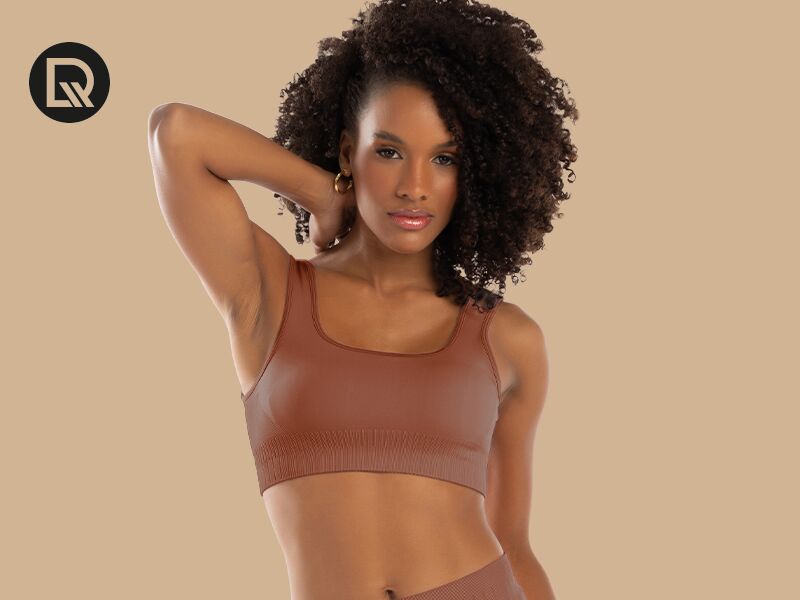 Modelo vestindo top marrom em fundo neutro