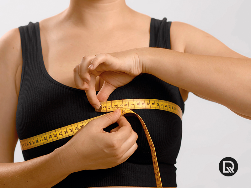 Mulher medindo o peito com fita métrica