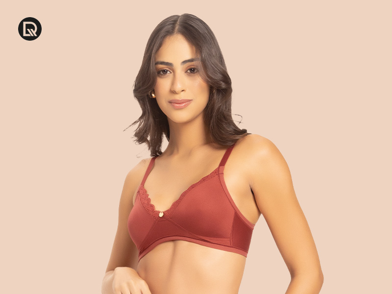 Modelo usando sutiã marrom em fundo neutro