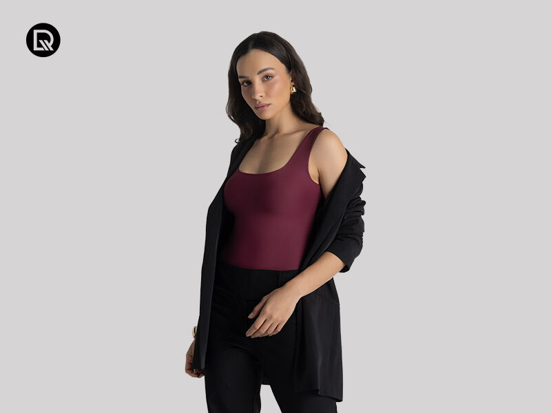 Modelo feminina com blusa marrom e blazer preto